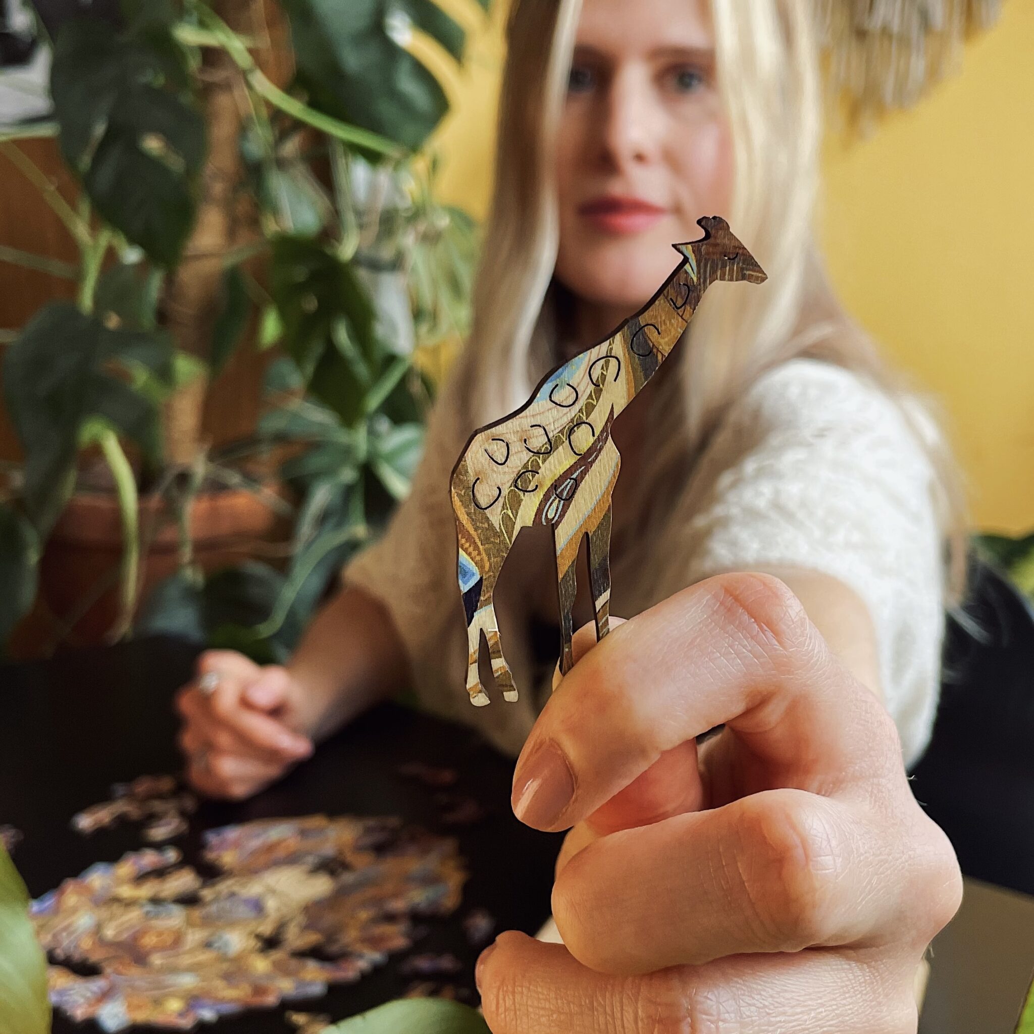 Hand holding a unique animal-shaped wooden puzzle piece