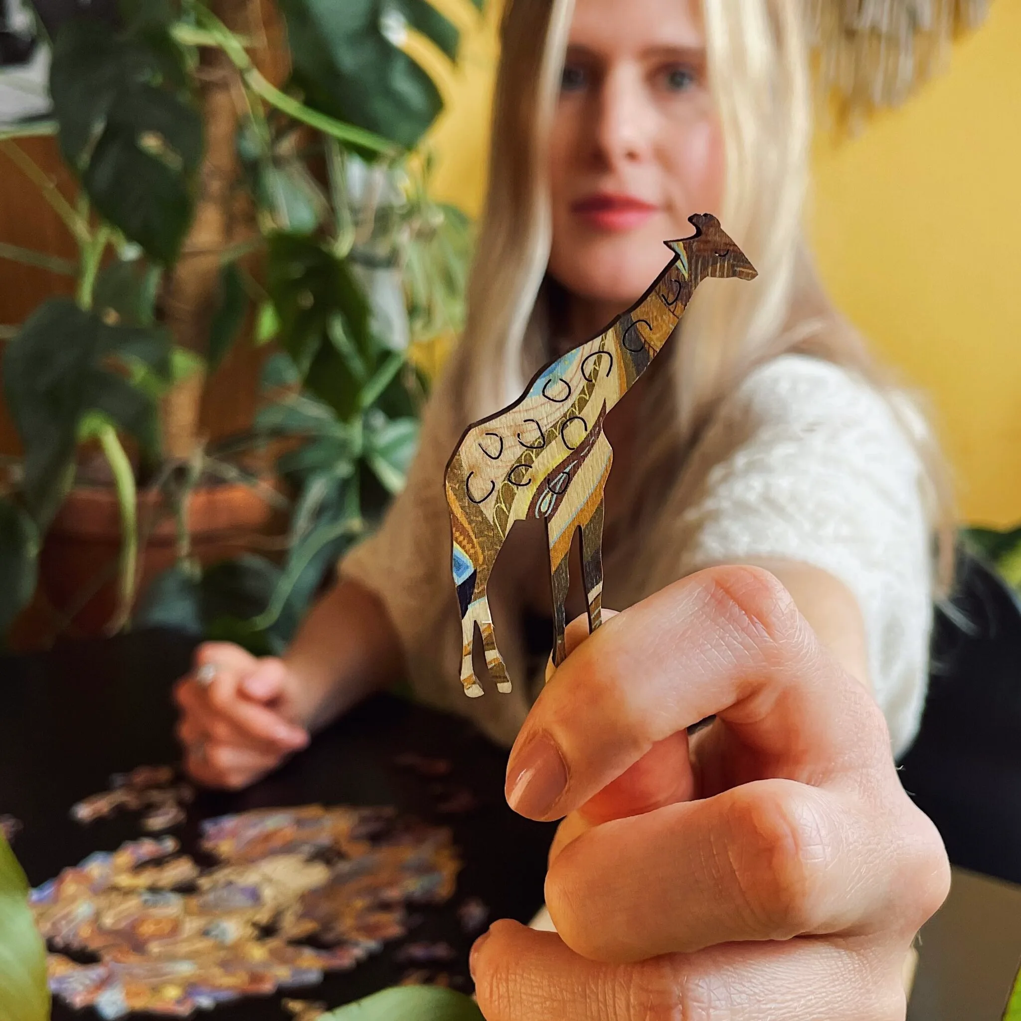 Hand holding a unique animal-shaped wooden puzzle piece